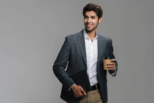 Zdjęcie Uśmiechniętego Nieogolonego Biznesmena Pijącego Kawę Wynos Trzymającego Laptopa Szarej — Zdjęcie stockowe