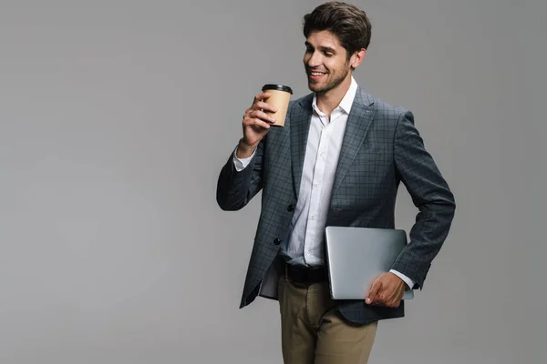 Foto Empresário Alegre Sem Barba Bebendo Café Takeaway Segurando Laptop — Fotografia de Stock