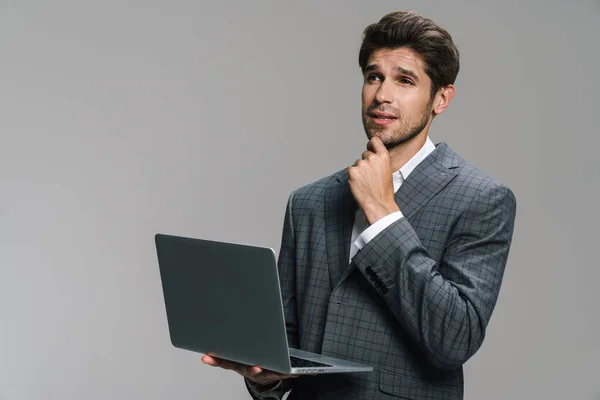 Foto Pensar Jovem Empresário Trabalhando Com Laptop Isolado Sobre Parede — Fotografia de Stock