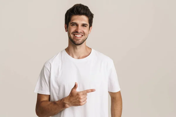 Portrait Joyful Young Man Basic Shirt Smiling Pointing Finger Aside — Stock Photo, Image