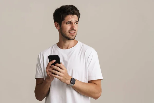 Portret Van Een Ontevreden Knappe Man Die Opzij Kijkt Mobiele — Stockfoto