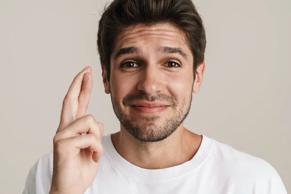 Portrait Pleased Young Man Smiling While Holding Fingers Crossed Good — Stock Photo, Image