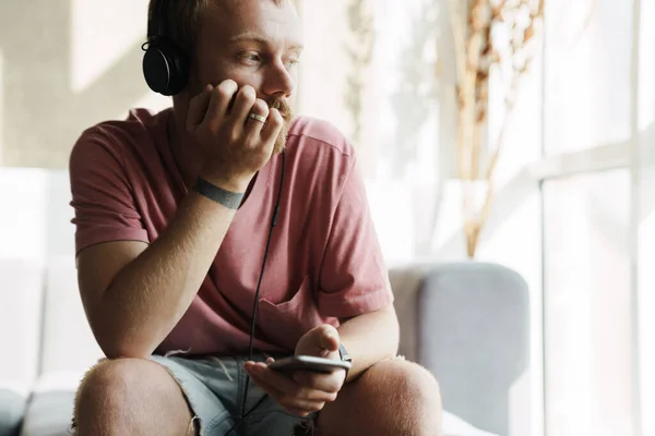 Foto Hombre Pelirrojo Pensando Con Barba Usando Teléfono Móvil Auriculares —  Fotos de Stock