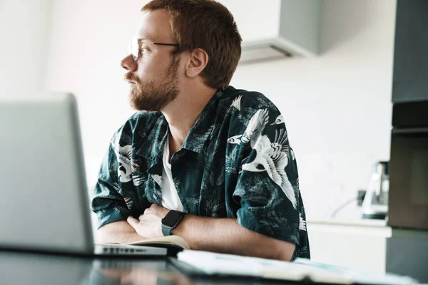 Foto Pelirrojo Enfocado Anteojos Trabajando Con Laptop Pensando Interiores — Foto de Stock