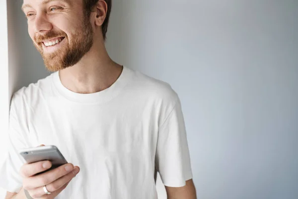 Photo Pleased Bearded Man Red Hair Using Mobile Phone Smiling — Stock Photo, Image