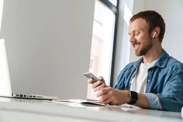 Foto Del Hombre Riendo Usando Auriculares Inalámbricos Teléfono Celular Mientras —  Fotos de Stock