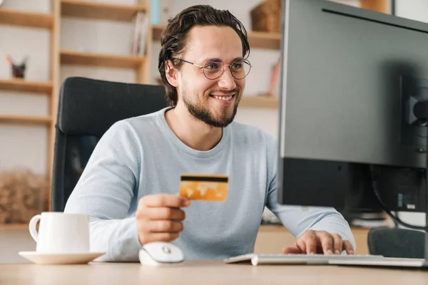 Imagem Homem Programador Sorrindo Usando Óculos Segurando Cartão Crédito Enquanto — Fotografia de Stock