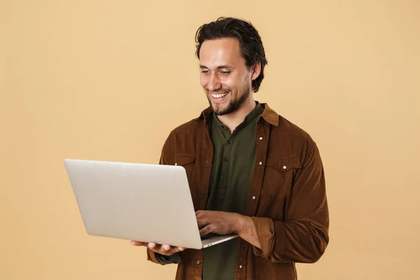 Immagine Uomo Barbuto Allegro Sorridente Digitando Notebook Isolato Sfondo Beige — Foto Stock