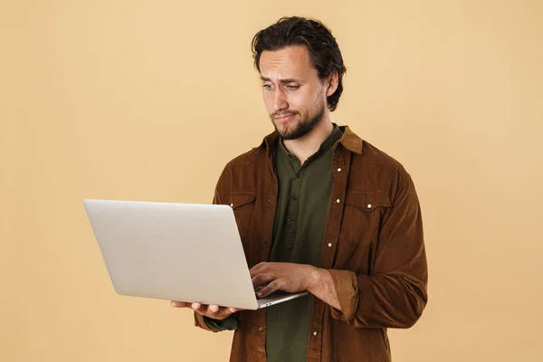 混乱した髭の男のイメージでカジュアルシャツタイプのノートブックに隔離された上ベージュの背景 — ストック写真