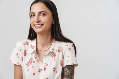 Beyaz arka planda izole edilmiş kameraya poz veren ve gülümseyen neşeli güzel bir kadının fotoğrafı.