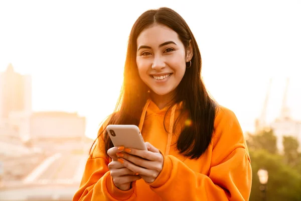 Foto Alegre Atractiva Mujer Asiática Sonriendo Usando Teléfono Móvil Mientras —  Fotos de Stock