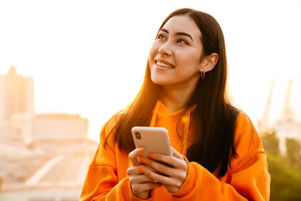Zdjęcie Radosnej Atrakcyjnej Azjatyckiej Kobiety Uśmiechającej Się Korzystającej Telefonu Komórkowego — Zdjęcie stockowe