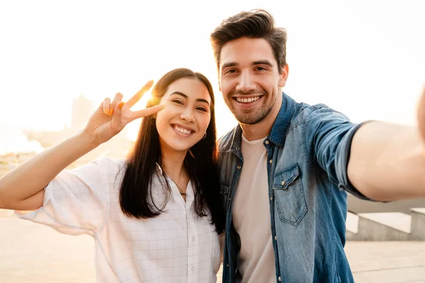 Imagem Casal Multicultural Sorridente Gesticular Sinal Paz Tirar Foto Selfie — Fotografia de Stock