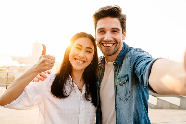 Imagem Casal Multicultural Sorridente Mostrando Polegar Para Cima Tirar Foto — Fotografia de Stock