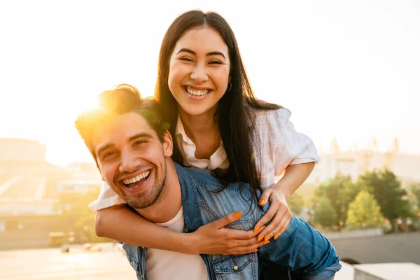 Beeld Van Vrolijk Multicultureel Koppel Meeliften Lachen Tijdens Het Wandelen — Stockfoto