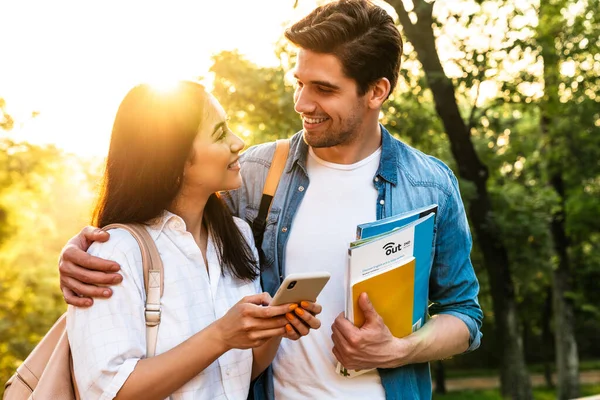 Imagen Una Alegre Pareja Estudiantes Multiculturales Usando Teléfono Móvil Sonriendo — Foto de Stock