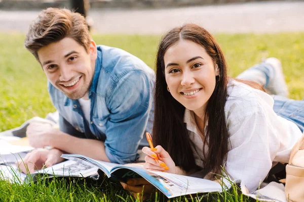 Imagem Casal Estudantil Multicultural Alegre Fazendo Lição Casa Sorrindo Enquanto — Fotografia de Stock