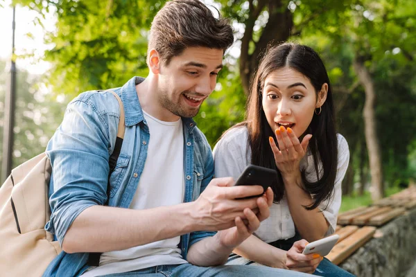 Bild Eines Überraschten Multikulturellen Paares Mit Mobiltelefonen Während Auf Einer — Stockfoto