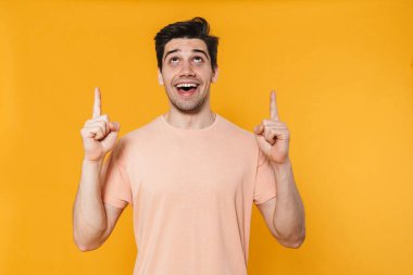 Sarı arka planda izole edilmiş mutlu ve yakışıklı bir adamın gülümsemesi.