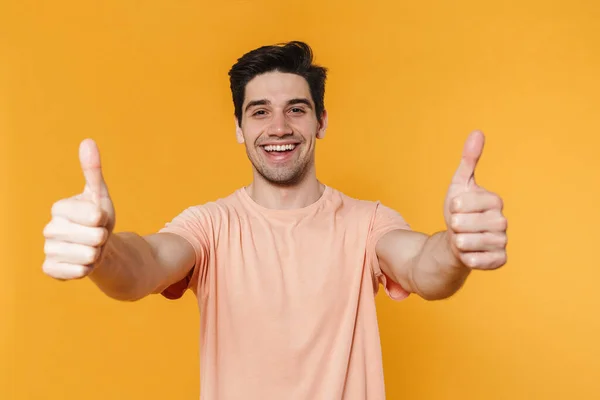 Photo Happy Handsome Man Showing Thumbs Smiling Isolated Yellow Background — ストック写真