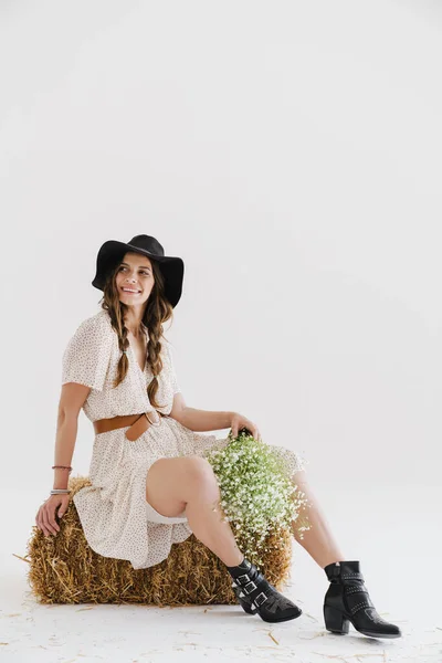 Фото Усміхненої Спокусливої Жінки Тримає Квіти Сидячи Сіні Ізольовано Білому — стокове фото