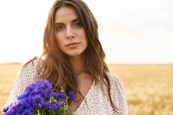 Buğday Tarlasında Çiçeklerle Yürürken Şık Giyinmiş Güzel Bir Kadının Fotoğrafı — Stok fotoğraf