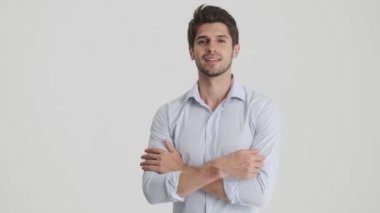 Başarılı bir adam, beyaz arka planda izole edilmiş kollarını tutarak kendine güvenen bir duruşta duruyor.