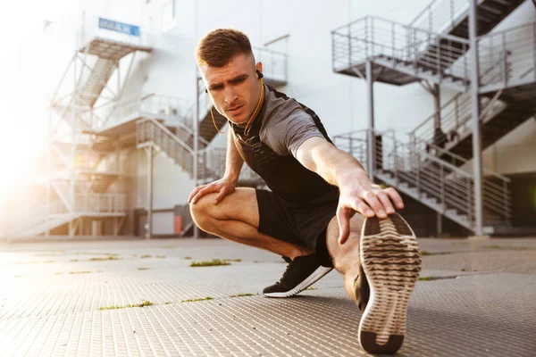 Wizerunek Nieogolonego Białego Sportowca Słuchawkach Ćwiczącego Podczas Treningu Terenie Miejskim — Zdjęcie stockowe