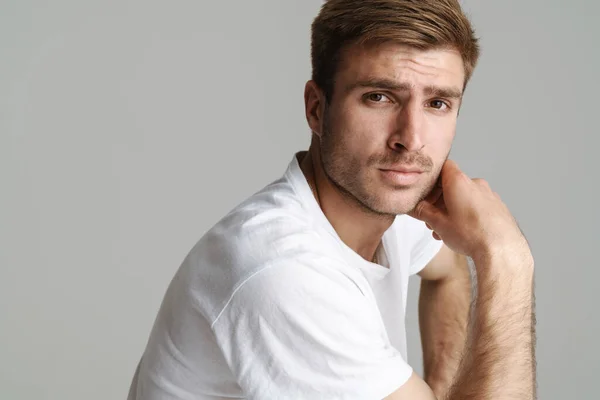 Portrait of redhead masculine man posing and looking at camera isolated over grey background