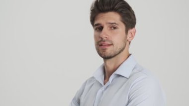 Kameraya gülümseyen genç bir adamın yakın çekim görüntüsü beyaz arka planda izole bir şekilde duruyor.