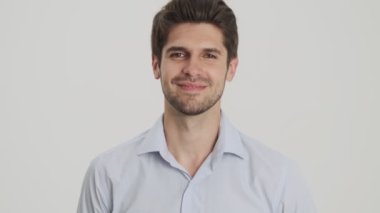 Mutlu bir gencin yakın plan görüntüsü, beyaz arka planda tek başına duran baş parmak hareketini gösteriyor.