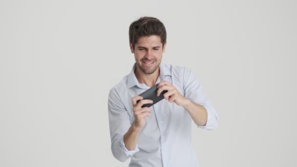 Homem Emocional Está Jogando Jogos Seu Smartphone Isolado Sobre Fundo — Vídeo de Stock