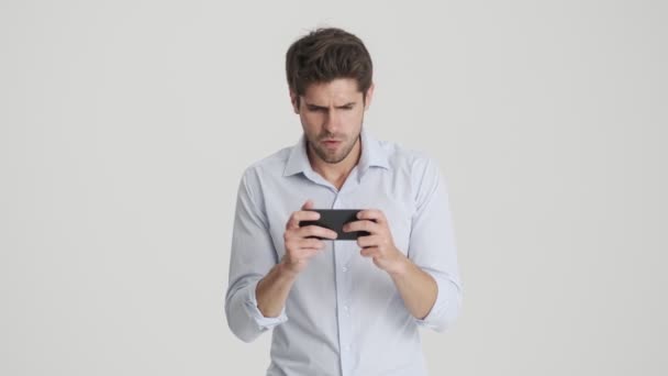 Uomo Felice Sta Giocando Sul Suo Smartphone Piedi Isolato Sfondo — Video Stock