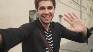 Binanın yanında dikilirken videoyla konuşan komik yakışıklı iş adamı.