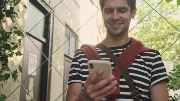 Gut Gelaunter Mann Benutzt Smartphone Während Auf Der Straße Steht — Stockvideo