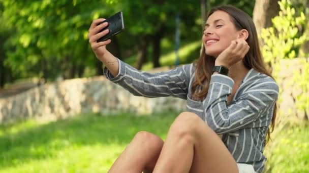Uśmiechnięta Atrakcyjna Brunetka Robi Selfie Smartfonie Siedząc Parku — Wideo stockowe