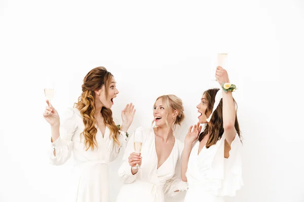 Foto Van Opgetogen Jonge Bruidsmeisjes Dansen Champagne Drinken Geïsoleerd Witte — Stockfoto