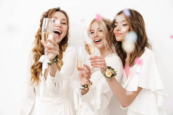 Photo Excited Beautiful Bridesmaids Laughing Drinking Champagne Isolated White Wall — Stock Photo, Image