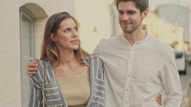 Birbirlerine sarılıp sokakta yürürken mutlu, genç ve güzel bir çift konuşuyorlar ve anın tadını çıkarıyorlar.