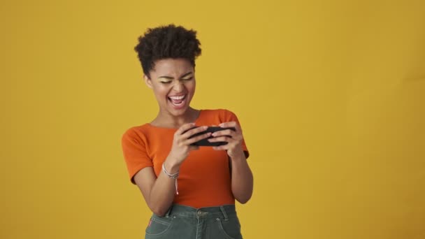 Vrolijke Aantrekkelijke Afrikaanse Vrouw Schreeuwen Verheugen Tijdens Het Spelen Smartphone — Stockvideo