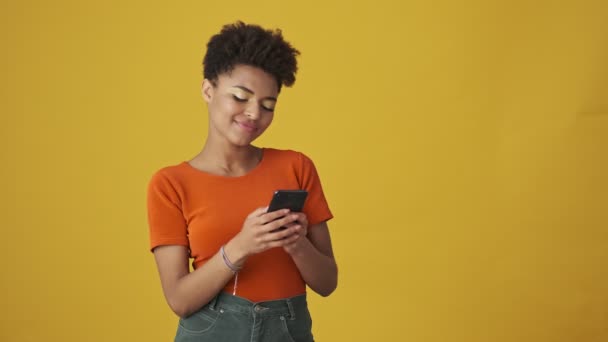 Pleased Attractive African Woman Writing Message Smartphone Yellow Background — Stock Video