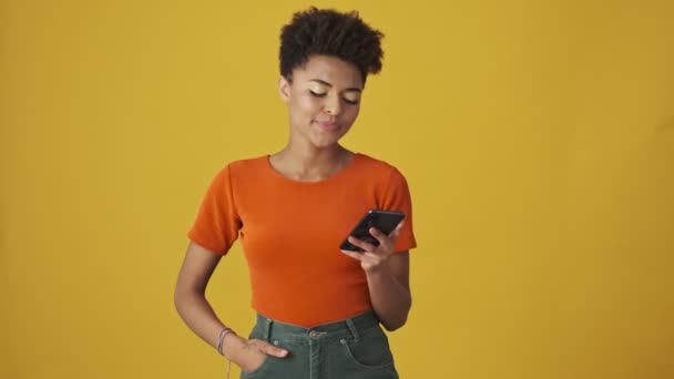Smiling Attractive African Woman Writing Message Smartphone Yellow Background — Stock Video