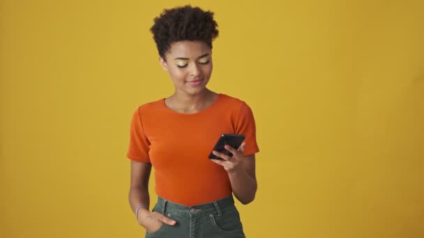 Agradável Mulher Africana Atraente Usando Smartphone Regozijo Sobre Fundo Amarelo — Vídeo de Stock