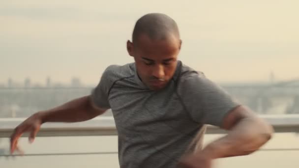 Genç Kaslı Bir Afrikalı Sabah Köprünün Dışında Isınma Egzersizleri Yapıyor — Stok video