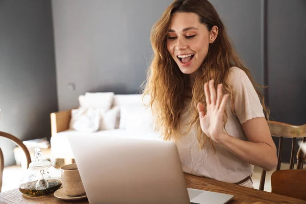 Schöne Fröhliche Junge Mädchen Sitzt Küchentisch Macht Einen Videoanruf Winkt — Stockfoto