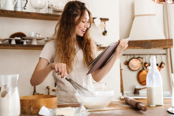 Vonzó Fiatal Vidám Lány Süt Konyhában Tésztát Csinál Receptkönyvet Tart — Stock Fotó