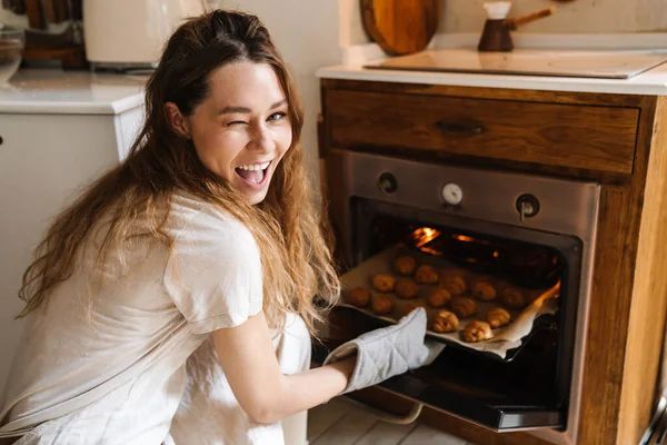 陽気若いです女の子取る焼きクッキーからザ オーブン ウィンク — ストック写真
