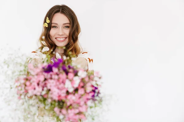 Photo of smiling woman with fake butterflies showing flowers at camera isolated over white wall