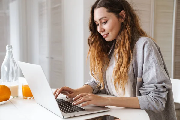 Hübsche Fröhliche Junge Frau Frühstückt Während Sie Küchentisch Sitzt Und — Stockfoto