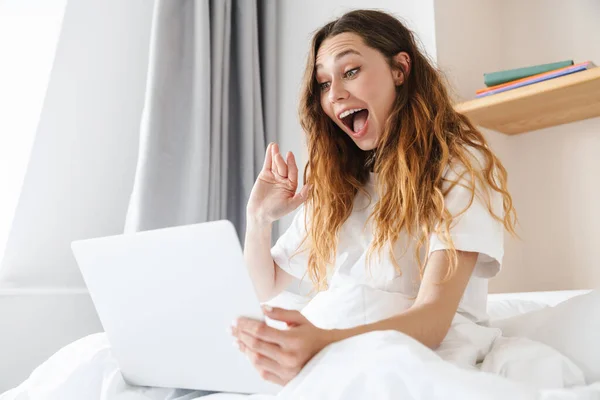 침대에 여성이 흔들며 노트북을 사용하는 — 스톡 사진